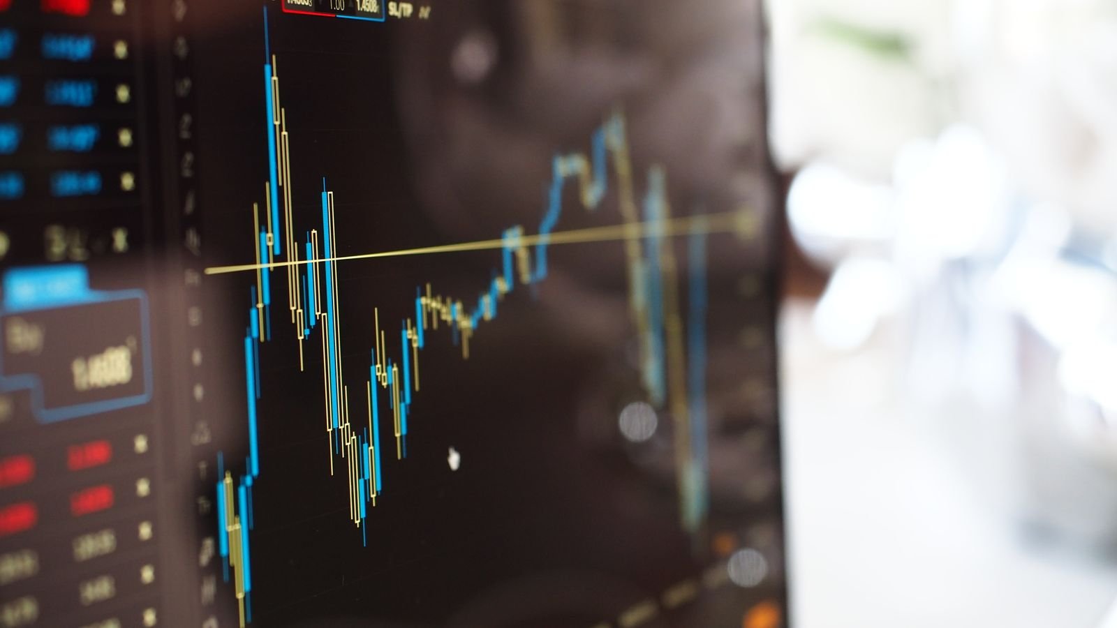 Close-up of a digital screen showing financial trading graphs, representing jobless claims and housing starts data
