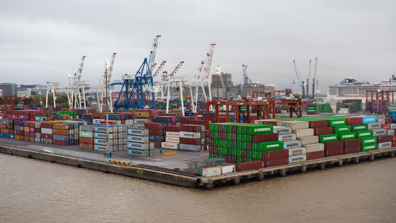 A bustling shipping port with stacked cargo containers and cranes, representing durable goods trade and manufacturing activity