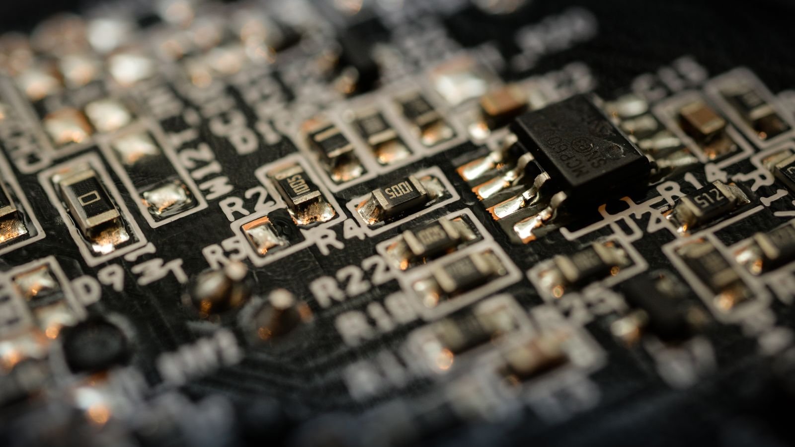Detailed close-up of a microchip on an electronic circuit board, representing tech sector capital allocation between buybacks and AI investment