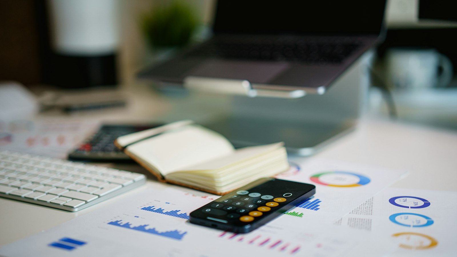 Office desk with smartphone and financial charts