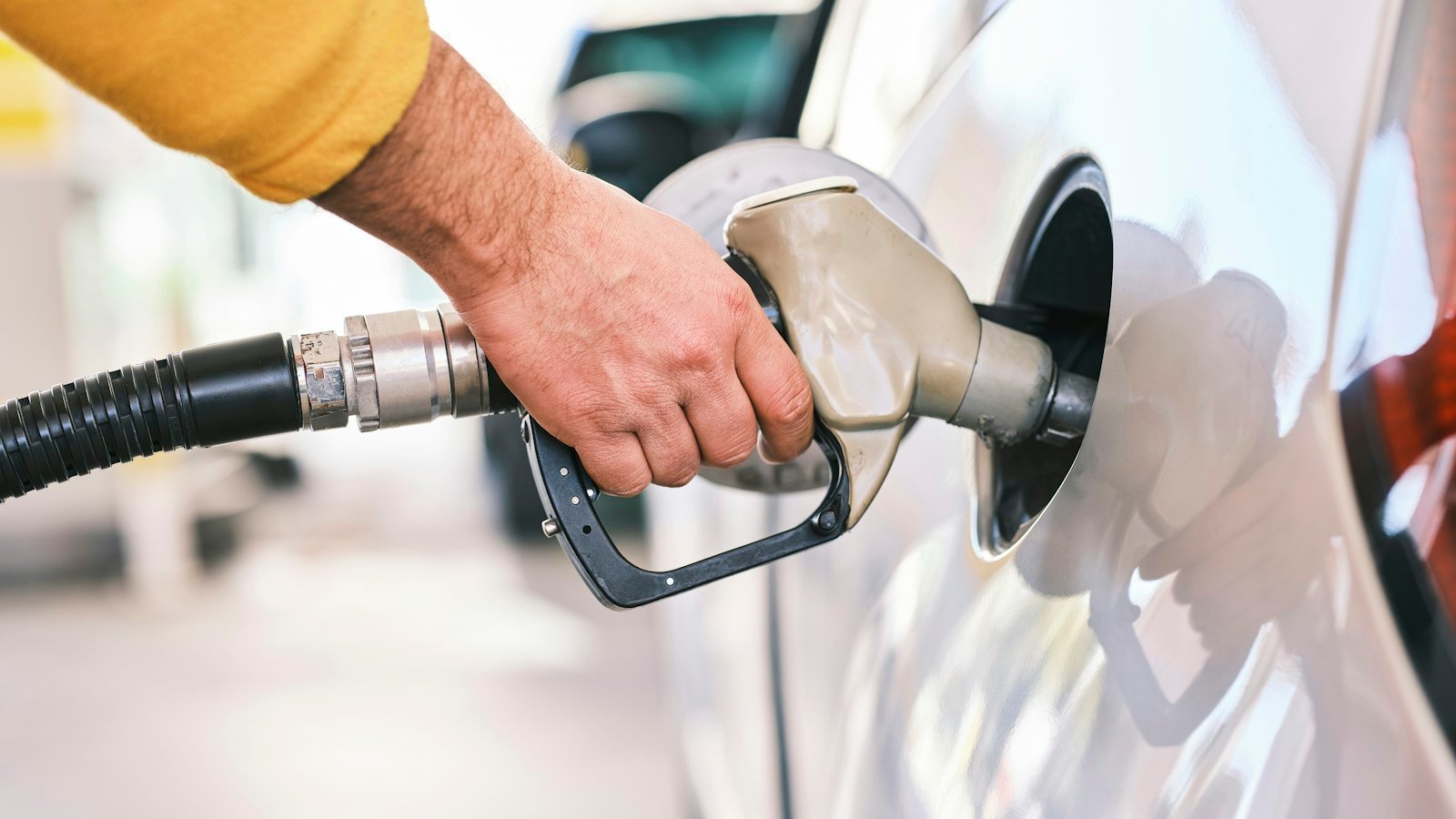 Driver pumping gasoline into a car at a gas station