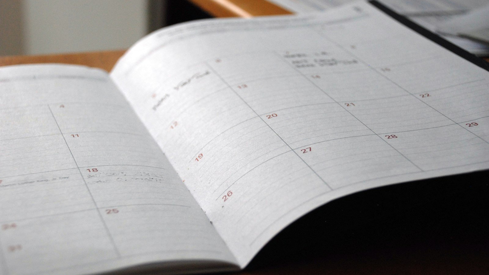 Open monthly planner on a wooden desk