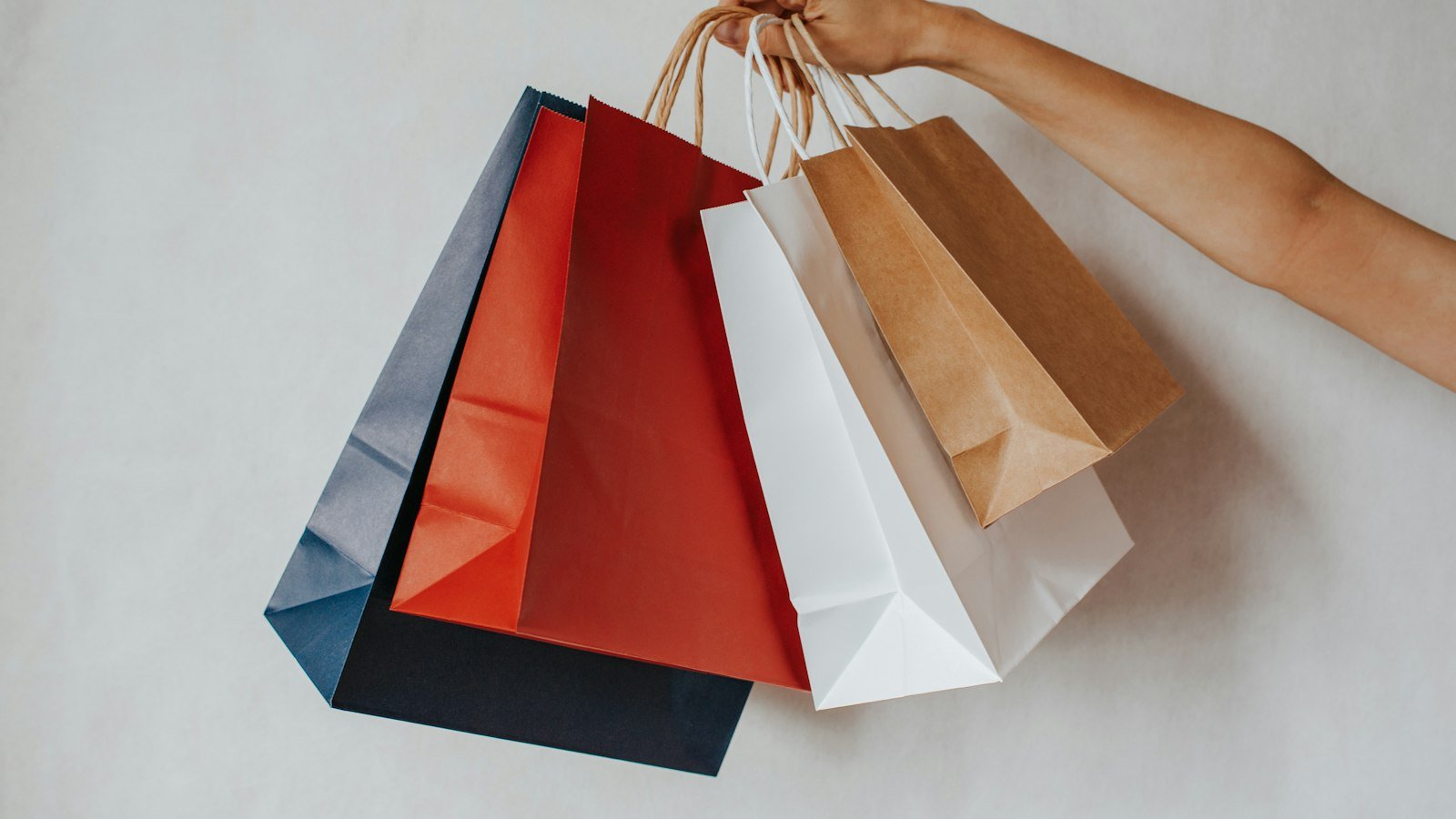 Hand holding colorful retail shopping bags