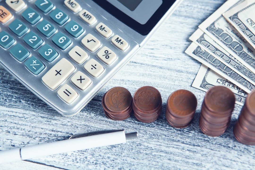 Calculator, pen and money on a table representing interest rate calculations