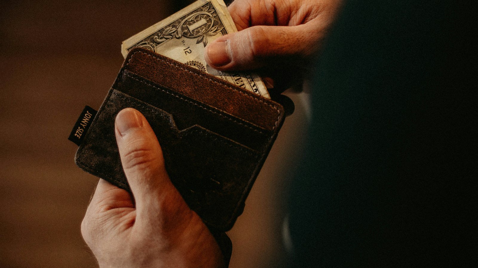 Person pulling a dollar bill out of a wallet